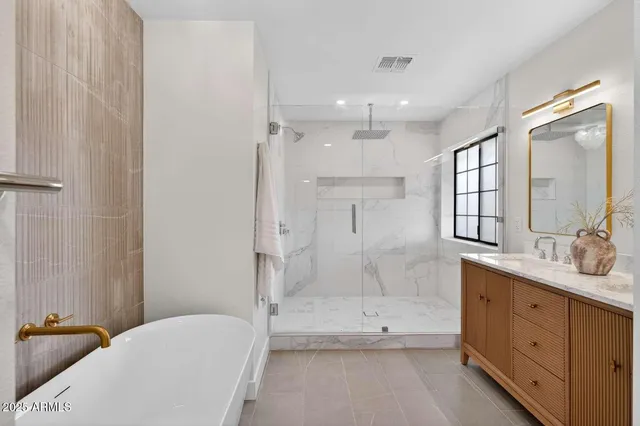a bathroom with a tub a sink and mirror