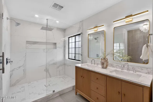 a bathroom with a double vanity sink mirror and shower