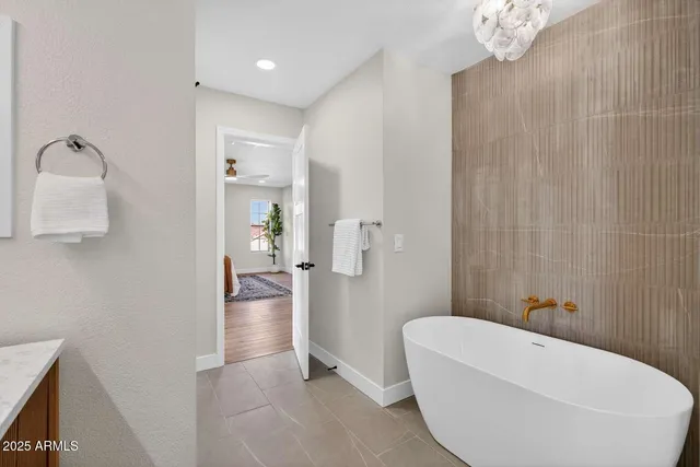 a bathroom with a tub sink and mirror