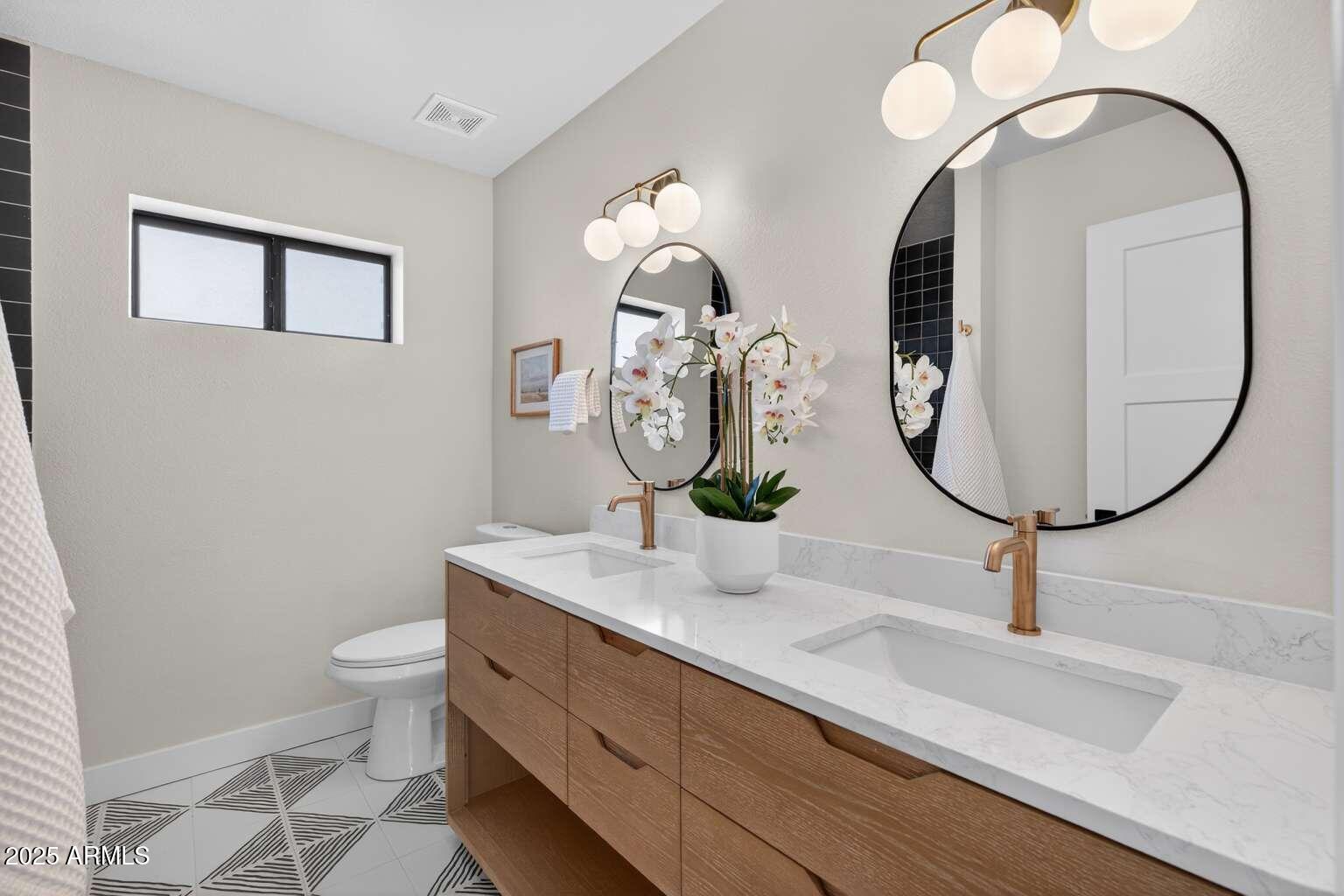 15850 North 15th Way Phoenix, AZ 85022 - Photo 31 of 43 a bathroom with a toilet a sink and mirror