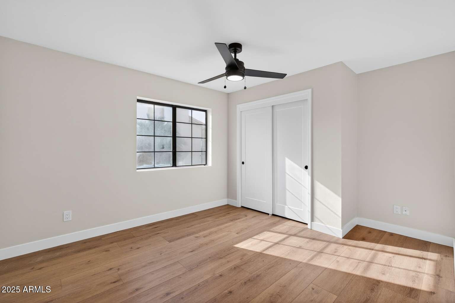 15850 North 15th Way Phoenix, AZ 85022 - Photo 33 of 43 a view of empty room with wooden floor and fan