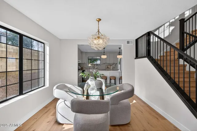 a dining room with furniture a chandelier and wooden floor