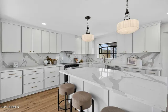 a kitchen with granite countertop white cabinets and chairs