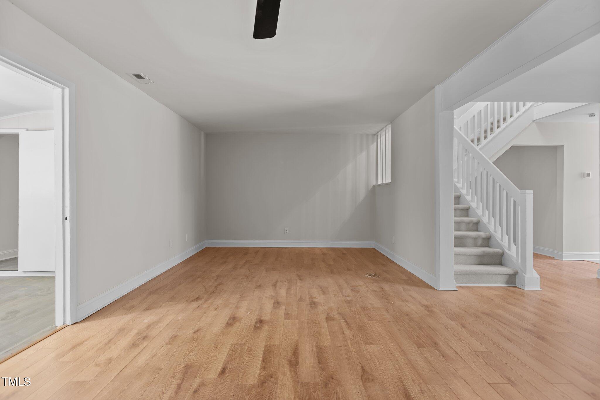1304 Seaton Road, Unit 24 Durham, NC 27713 - Photo 20 of 38 a view of an empty room with wooden floor and stairs