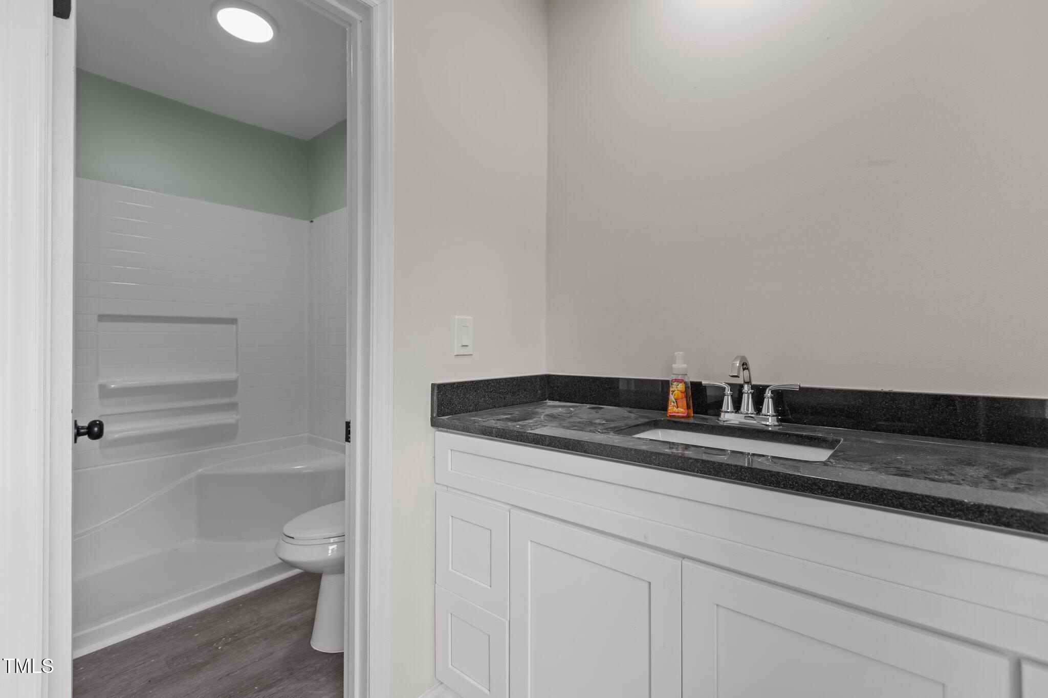 1304 Seaton Road, Unit 24 Durham, NC 27713 - Photo 27 of 38 a bathroom with a granite countertop sink and a toilet