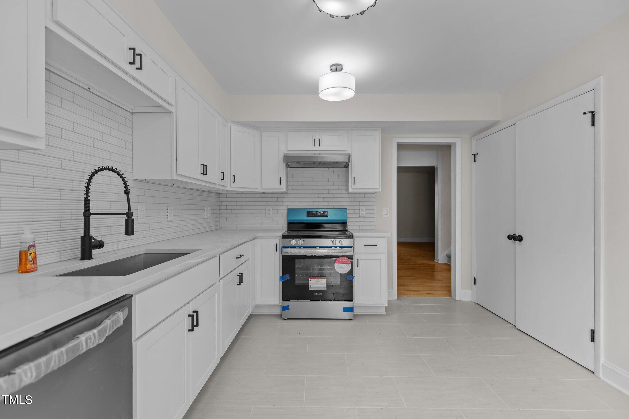 1304 Seaton Road, Unit 24 Durham, NC 27713 - Photo 8 of 38 a kitchen with stainless steel appliances and white cabinets