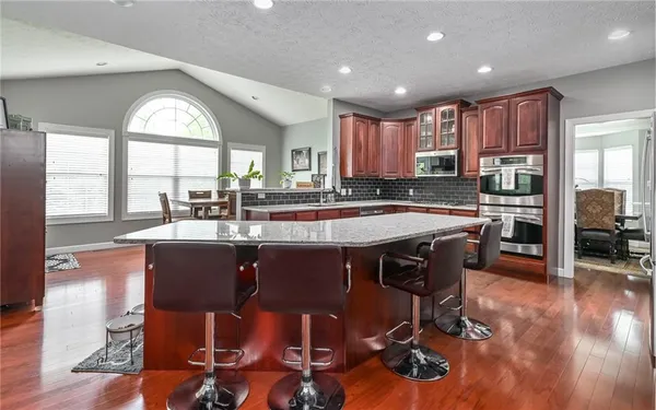a kitchen with stainless steel appliances granite countertop a sink a stove and a refrigerator