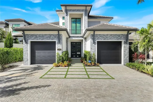 a front view of a house with yard and trees