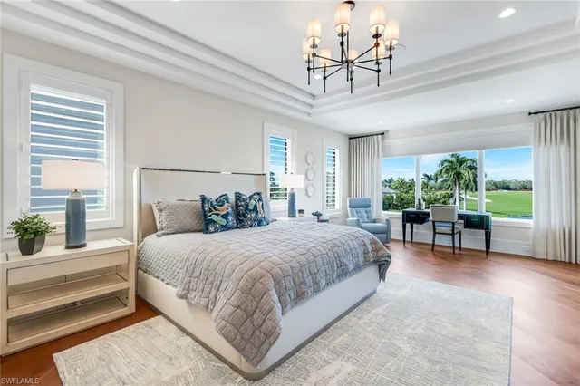 a bedroom with a large bed and a chandelier