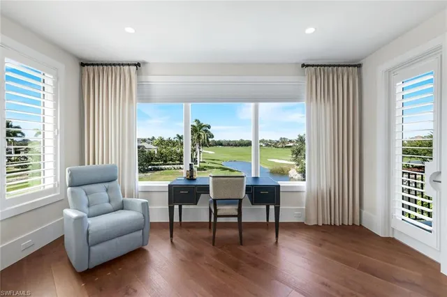 a living room with furniture and a large window with wooden floor