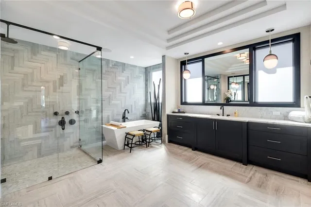 a spacious bathroom with a tub sink mirror and a shower