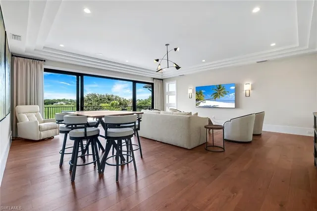 a living room with furniture wooden floor and a large window