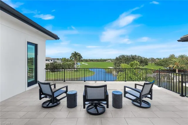 a view of a lake with outdoor seating and barbeque oven