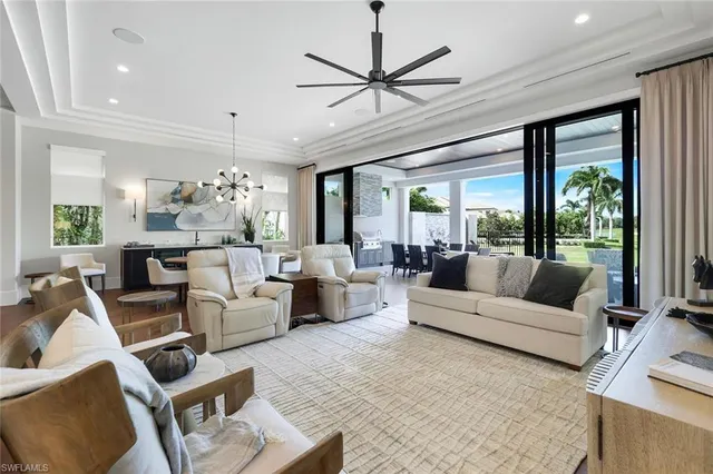 a living room with furniture ceiling fan and a large window
