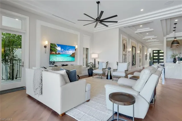 a living room with furniture a ceiling fan and a flat screen tv