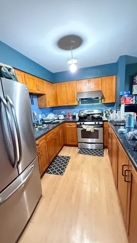 a kitchen with stainless steel appliances granite countertop a sink and a refrigerator