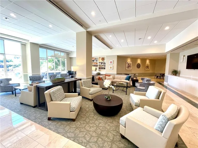 a living room with furniture a table and kitchen view