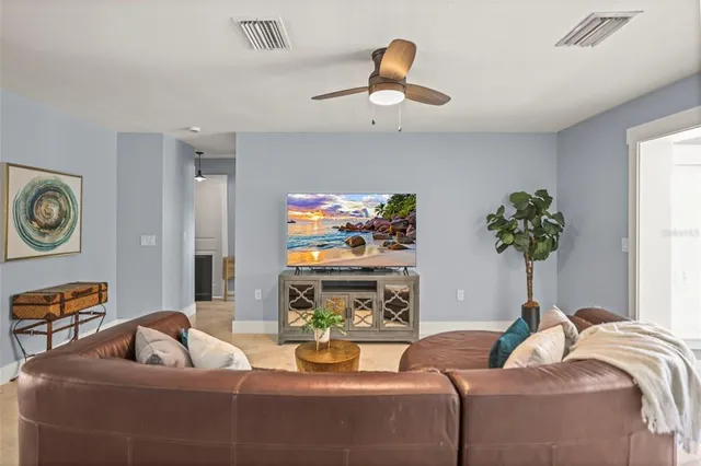 a living room with furniture a wooden floor and a chandelier