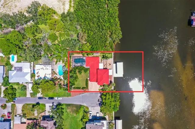 an aerial view of residential house with outdoor space and trees all around