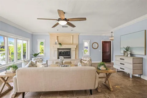 a living room with furniture a fireplace and a large window