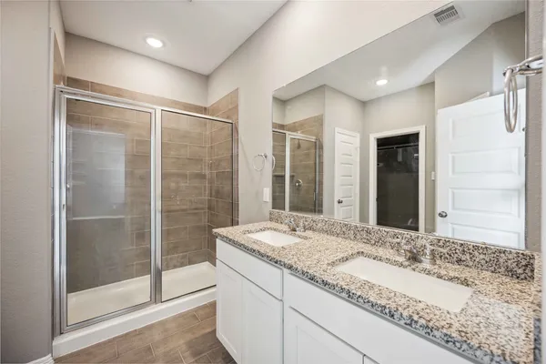 a bathroom with a granite countertop sink mirror and shower