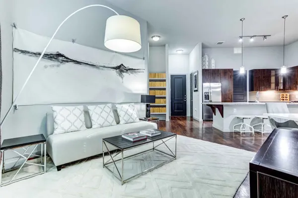 a living room with stainless steel appliances kitchen island granite countertop furniture and a wooden floor