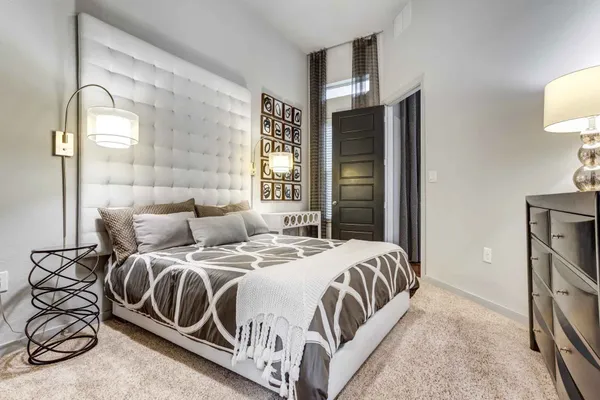 a bedroom with a bed a mirror and lamp