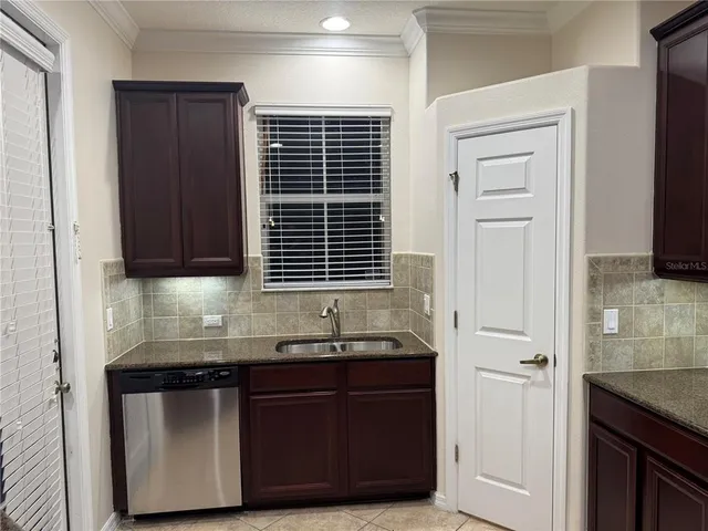 a kitchen with granite countertop wood cabinets and stainless steel appliances
