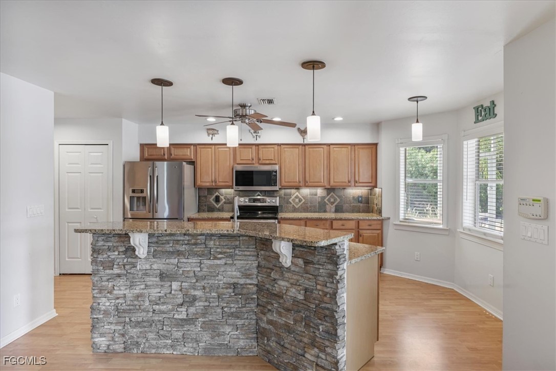 2870 Hickey Creek Road Alva, FL 33920 - Photo 13 of 45 a large kitchen with kitchen island granite countertop a large counter top stainless steel appliances and cabinets