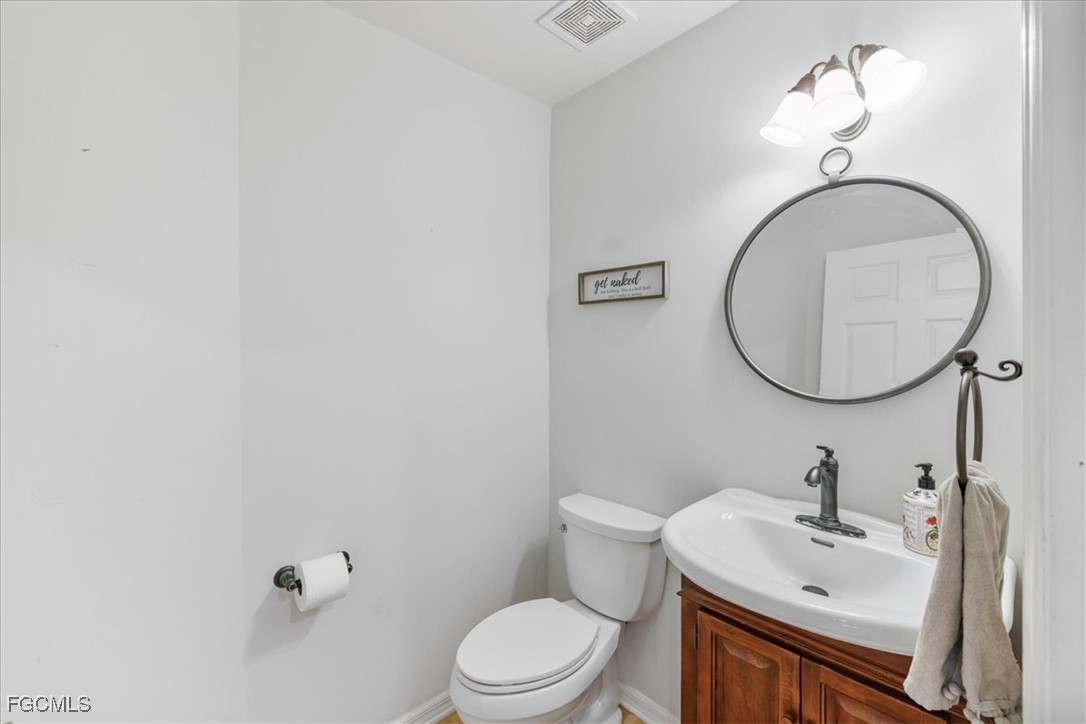 2870 Hickey Creek Road Alva, FL 33920 - Photo 21 of 45 a bathroom with a toilet a sink and mirror