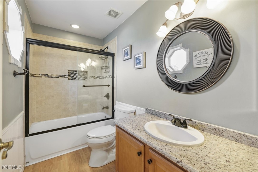 2870 Hickey Creek Road Alva, FL 33920 - Photo 27 of 45 a bathroom with a granite countertop toilet a sink and a mirror