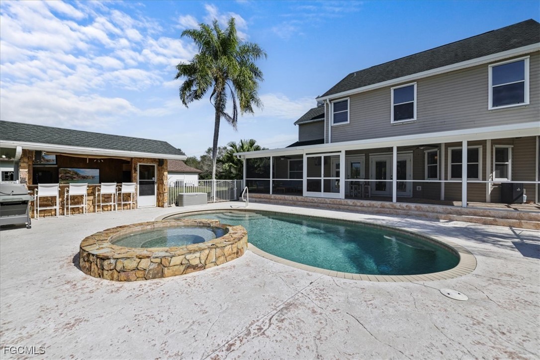 2870 Hickey Creek Road Alva, FL 33920 - Photo 35 of 45 a view of a house with swimming pool and a porch