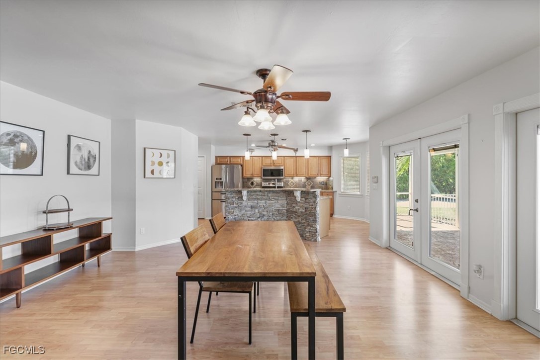 2870 Hickey Creek Road Alva, FL 33920 - Photo 10 of 45 a dining room with wooden floor and chandelier