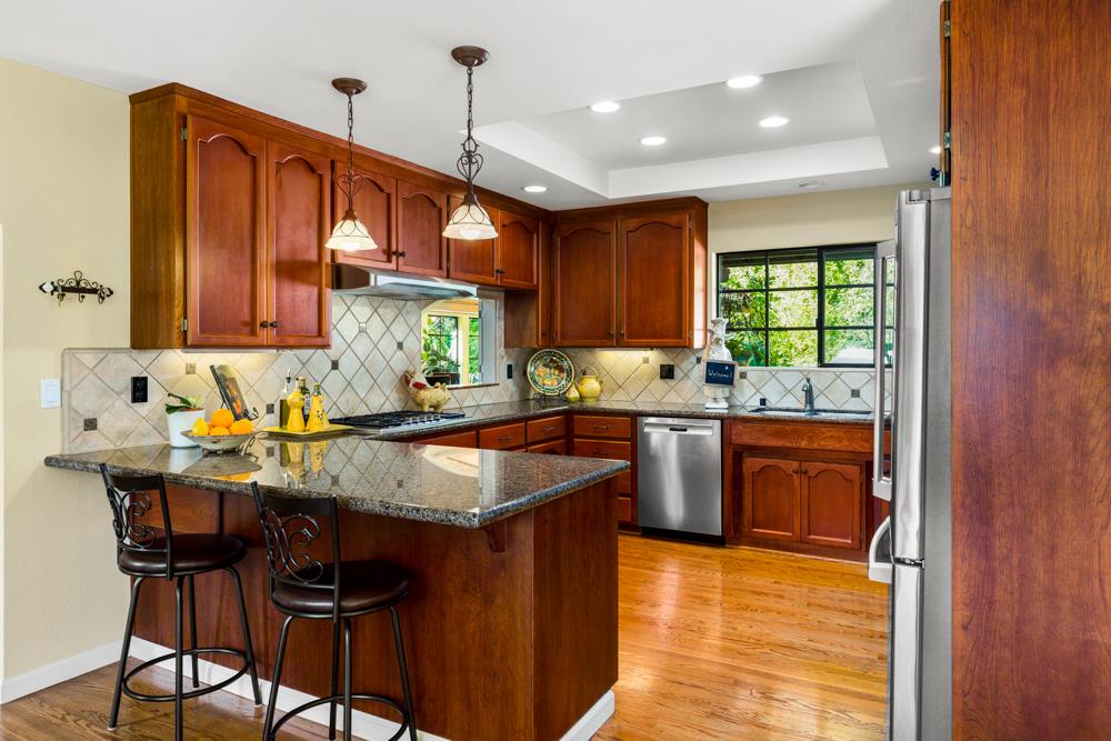 115 Santa Fe Ridge Aptos, CA 95003 - Photo 17 of 50 a kitchen with granite countertop wooden cabinets a counter top space a sink and appliances