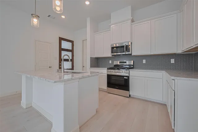 a view of a kitchen with a sink and wooden floor