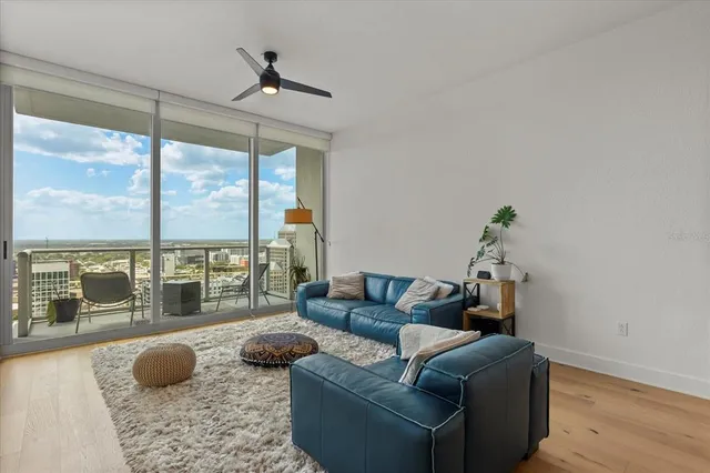 a living room with furniture and a floor to ceiling window