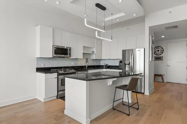 a kitchen with stainless steel appliances granite countertop a stove a sink a refrigerator and a microwave