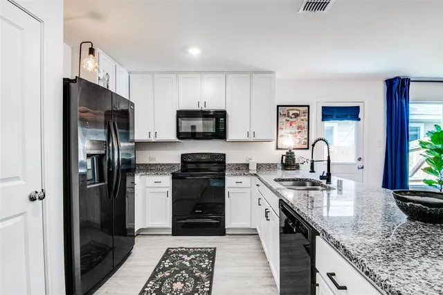 a kitchen with stainless steel appliances granite countertop a stove refrigerator sink and microwave