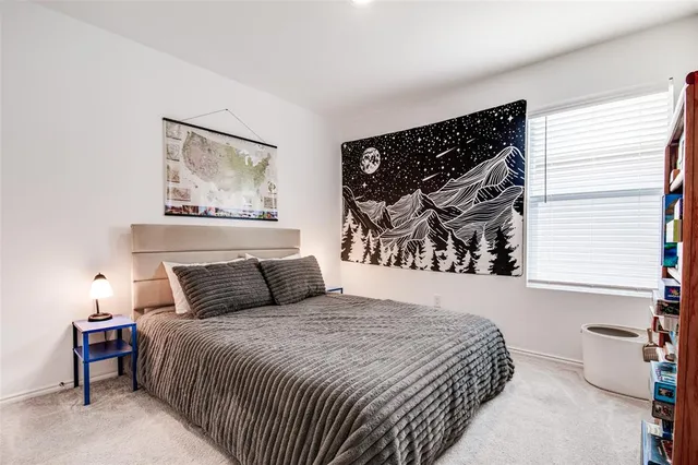 a bedroom with a bed and painting on the wall