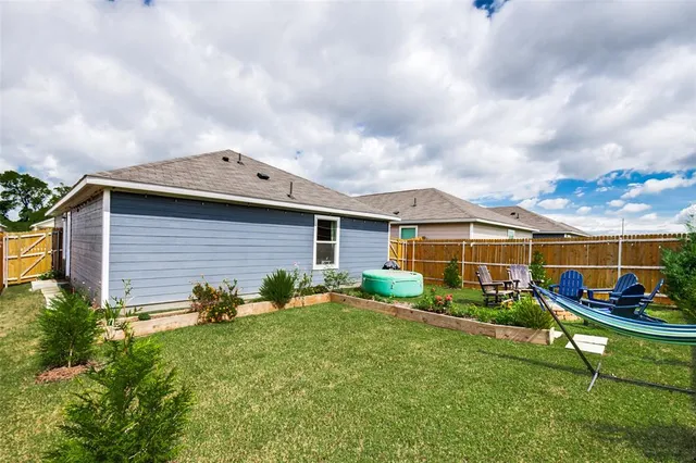 a backyard of a house with barbeque oven table and chairs