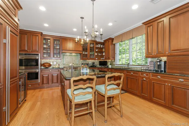 a kitchen with stainless steel appliances granite countertop a table and chairs in it