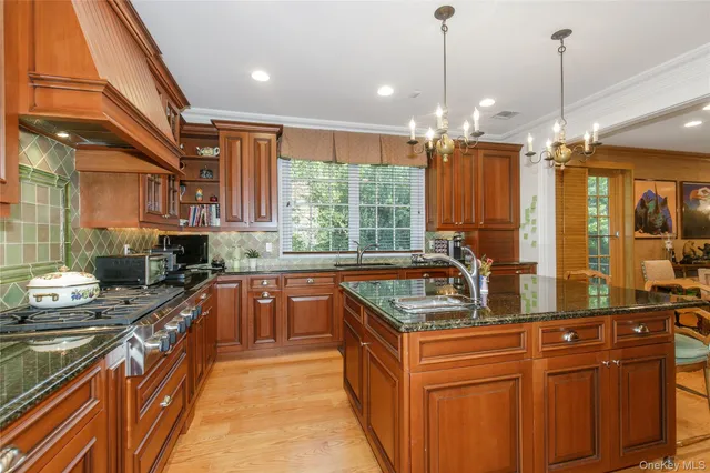 a kitchen with stainless steel appliances granite countertop a sink a stove and a wooden floors