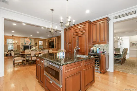 a kitchen with stainless steel appliances granite countertop a stove and a view of living room