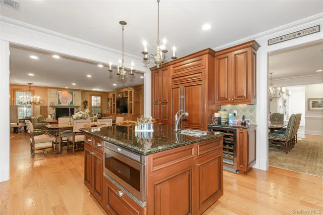 a kitchen with stainless steel appliances granite countertop a stove and a view of living room