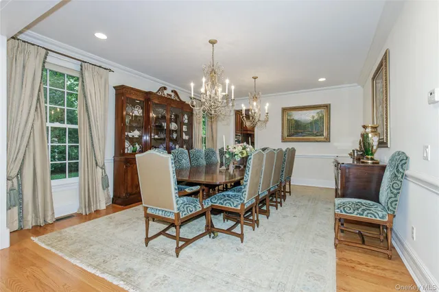 a living room with furniture a chandelier and a dining table