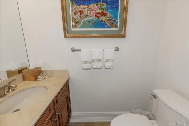 a bathroom with a granite countertop sink mirror vanity and toilet