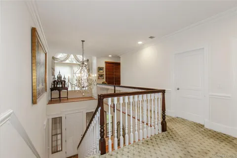 a view of a hallway with a dining table chairs