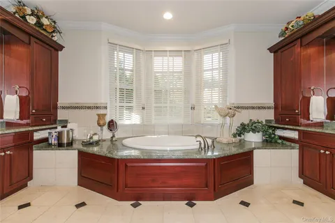 a spacious bathroom with a tub sink and mirror