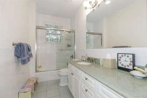 a bathroom with a granite countertop sink a toilet and a mirror