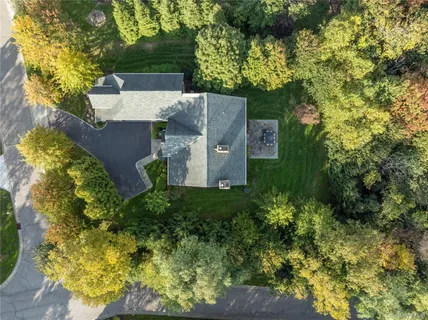 an aerial view of a house with a yard and large trees